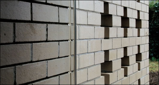 Cruciform details set into an exterior wall viewed through the virtually invisible living room window Cruciform details set into an exterior wall viewed through the virtually invisible living room window